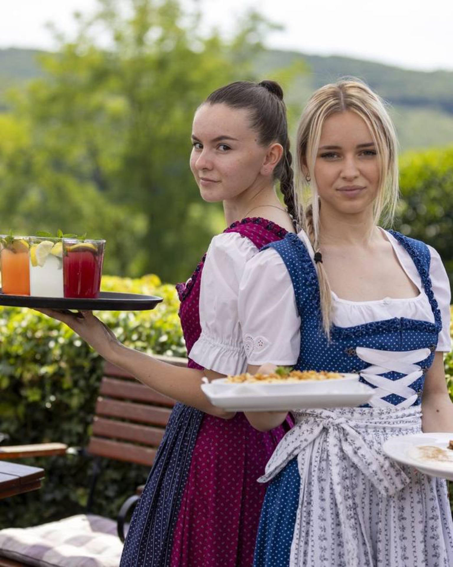 Kellnerinnen im Dirndl servieren Speisen und Getränke im Schwabenhof