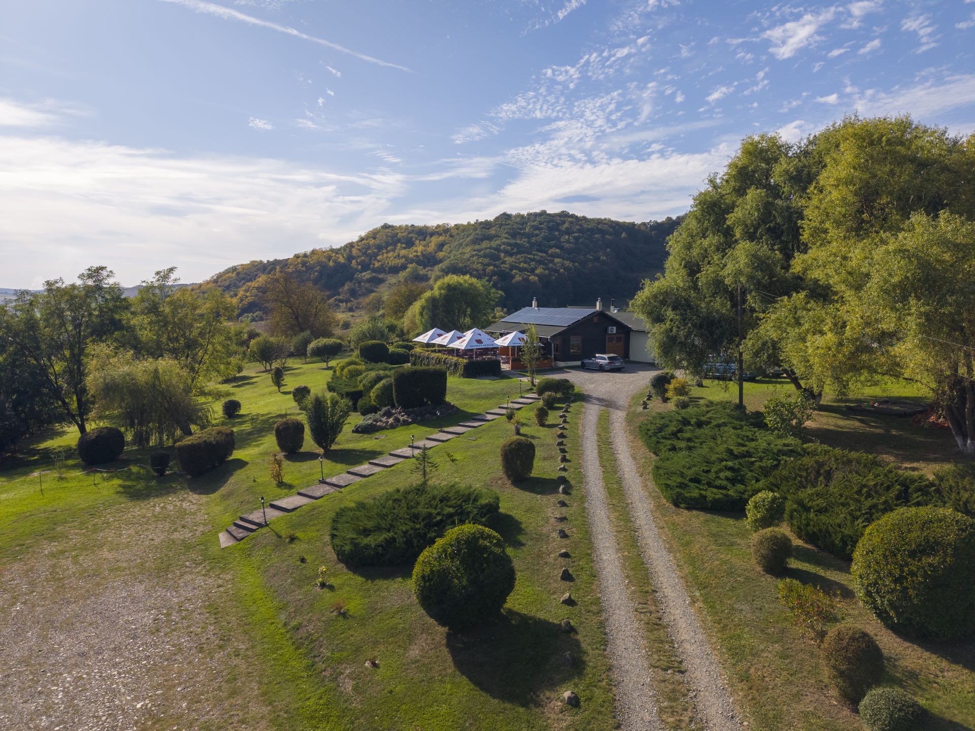 Luftaufnahme des Schwabenhof mit Gartenweg und Sonnenschirmen